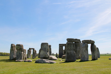 View of Stonehenge with green meadow and blue sky on a sunny day in Spring, United Kingdom
