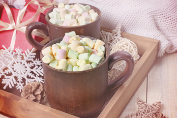 Winter background. Two Clay mugs with hot cocoa and marshmallow , gift boxes , ball, snowflake in the wooden box.