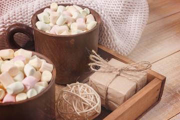 Winter background. Clay mug with hot cocoa and marshmallow , gift box, ball in the wooden box.
