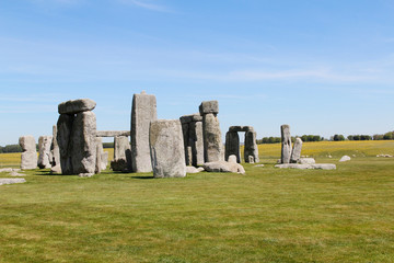 View of Stonehenge with green meadow and blue sky on a sunny day in Spring, United Kingdom