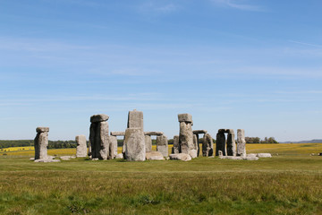 View of Stonehenge with green meadow and blue sky on a sunny day in Spring, United Kingdom