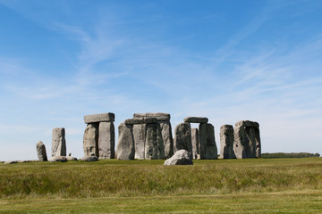 View of Stonehenge with green meadow and blue sky on a sunny day in Spring, United Kingdom
