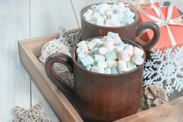 Winter background. Two Clay mugs with hot cocoa and marshmallow , gift boxes , ball, snowflake in the wooden box.