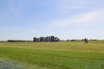 View of Stonehenge with green meadow and blue sky on a sunny day in Spring, United Kingdom