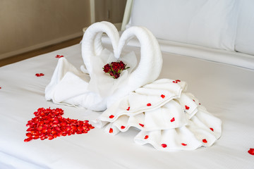Swan towel on bed with red rose flower decoration interior