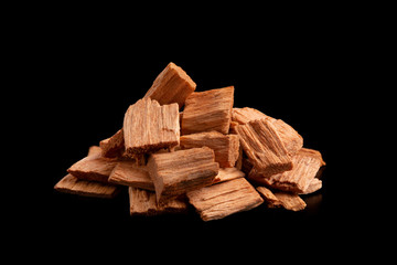 Chips alder. Wood chips. A pile of small slivers of alder on a black background. Chips for smoking products close-up. 