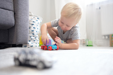 kid boy playing with toy at home or kindergarten