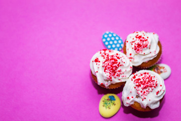 on a pink background close-up of colored Easter eggs and cupcake, holiday background