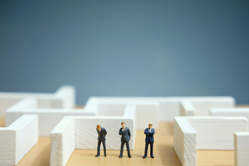 Business strategy conceptual photo - Miniature of businessman looking for solution on a labyrinth maze