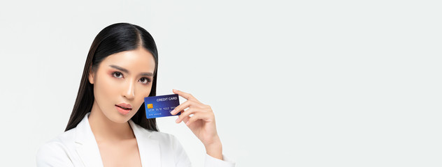 Beautiful elegant Asian woman showing credit card isolated on white banner background  with copy...