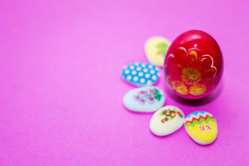 on a pink background close-up of colored Easter eggs and cupcake, holiday background