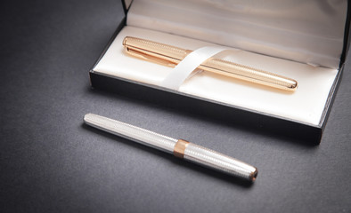 Pens and box on the black background.