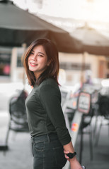 Portrait of Smart Asian Woman Smiling in Front of Coffee Shop at Co-Working Space in Shopping Center on Business District Location - Happy Emotion Relax Concept (Vintage Film Tone)