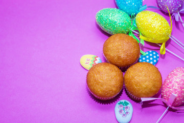 on a pink background close-up of colored Easter eggs and cupcake, holiday background