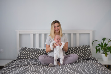 Pretty woman holding a newborn baby in her arms