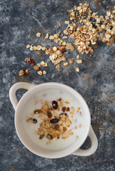 Yoghurt bowl with granola in a white bowl, top view. Healthy vegan food breakfast concept.
