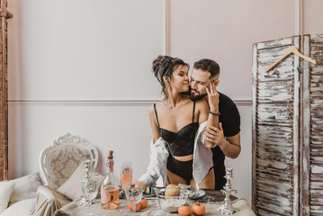 sensual Italian couple stands and kisses in the kitchen Romantic dinner for a young couple in love. Love story. Photo session of lovers in the kitchen