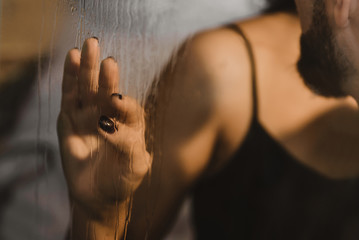 Sex behind glass. Male and female hand on the window.  the proximity of a couple in love behind a fogged glass. passion