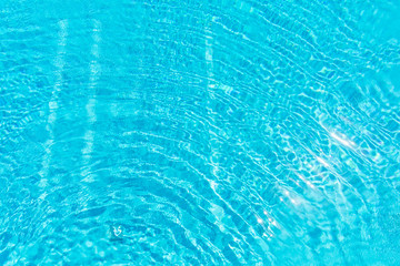 Fototapeta na wymiar Surface of blue shining swimming pool water ripple. Perfect as a background for summer, vacation, calmness, serenity or any other idea.