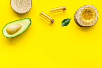 Avocado oil - skin care concept - on yellow background top-down frame copy space