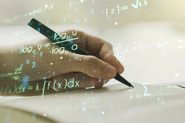 Creative scientific formula hologram with man hand writing in notepad on background, research...