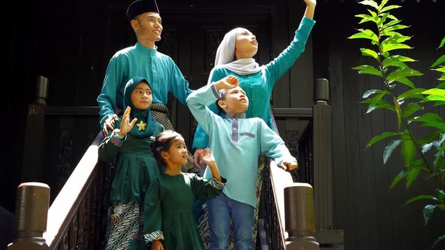 Malay Family Standing At Front Yard Waving Said Goodbye