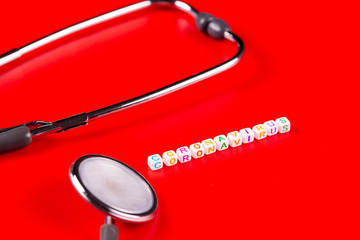 Pandemic and virus concept - Coronavirus text with syringe and phonendoscope on red background....