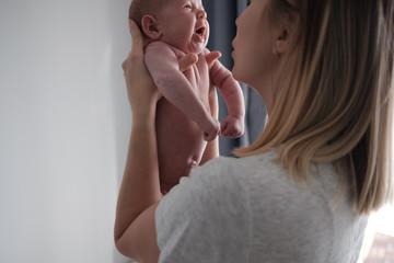 Pretty woman holding a newborn baby in her arms.