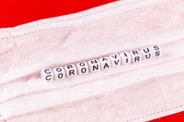 Coronavirus word made of letters on red background . The inscription on medical protective mask coronavirus.