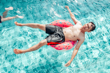 Holiday, vacation concept, Father and son swimming in the pool during the day. Very happy and fun.