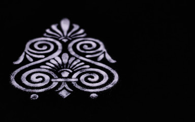top angle view of an awesome white rangoli on black background with copy space. diwali concept