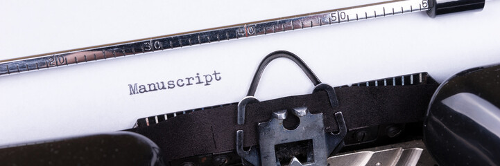 The word Manuscript typed on retro black typewriter. Panoramic image