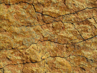 Red grunge background. Rock texture with cracks. Red brown yellow mountain texture closeup. Cracked stone surface. Natural stone background.
