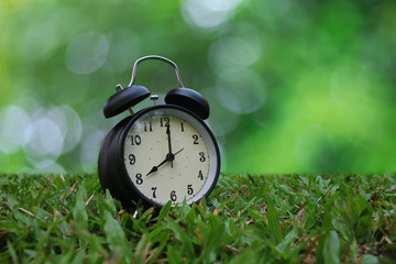 alarm clock on green grass