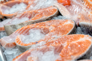 Chilled steaks of red fish. Pieces of fish lie on ice.