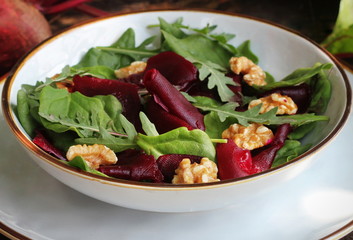 Vegetarian food. Healthy Beet Salad with fresh sweet baby spinach, arugula, nuts