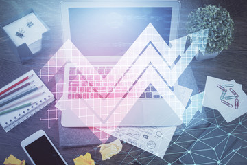 Fototapeta premium Computer on desktop with point up arrows hologram. Double exposure. Concept of success.