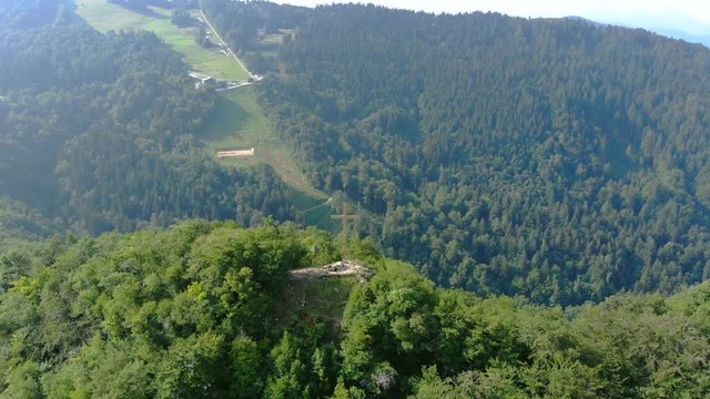 Aerial view of an amazing mountainous landscape. Big cross on top of the mountain. Parallax shot. Celje, Slovenia