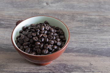 Dark roasted coffee beans in a cup.