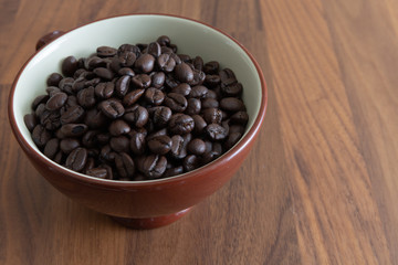 Dark roasted coffee beans in a cup.