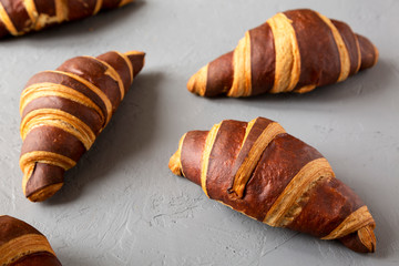 Homemade Croissants with Chocolate on gray surface, low angle view. Close-up.