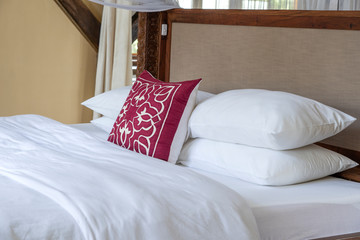 Comfortable soft bed and pillows in room, close up