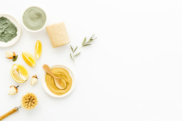 Clay mask, natural facial cosmetic set with herbals on white background - top view