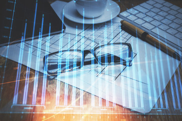 Financial chart hologram with glasses on the table background. Concept of business. Double exposure.