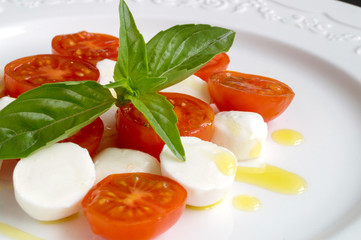 Caprese salad with ripe tomatoes and mozzarella with fresh Basil leaves. Italian food.