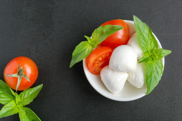 Caprese salad with ripe tomatoes and mozzarella with fresh Basil leaves. Italian food.