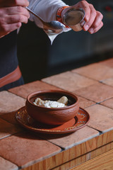Vareniki dumplings, traditional Ukrainian food served in a ceramic bowl in a restaurant.