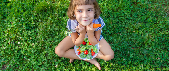 child eats vegetables broccoli and carrots. Selective focus.