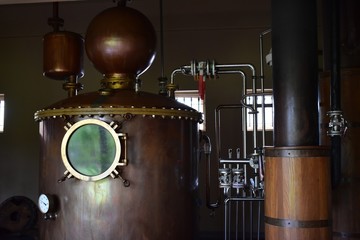 Fototapeta na wymiar Alcohol distillation equipment, vintage copper tank with gauge.