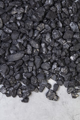 Natural black coal on a gray granite background
